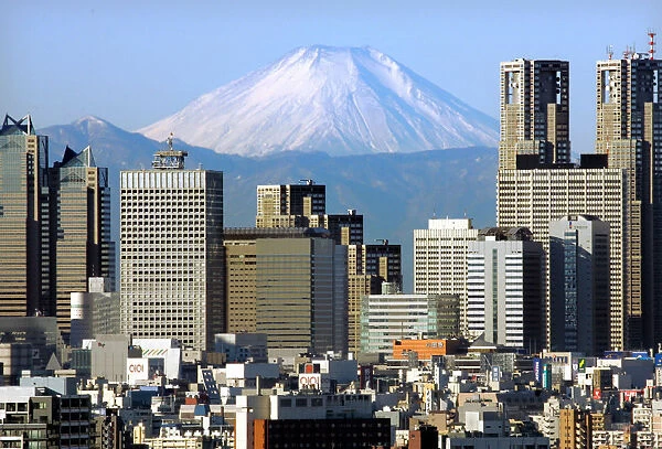 Japans Mt Fuji, covered with snow, is seen through Shinjuku skyscrapers in Tokyo
