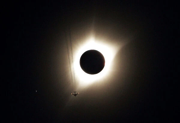 A jet plane flies by the total solar eclipse in Guernsey