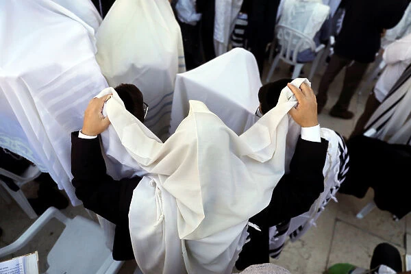 Jewish worshippers wrapped in prayer shawls participate in the priestly blessing prayer