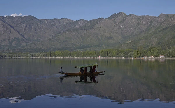 A Kashmiri man rows his boat on the waters of Dal Lake in Srinagar