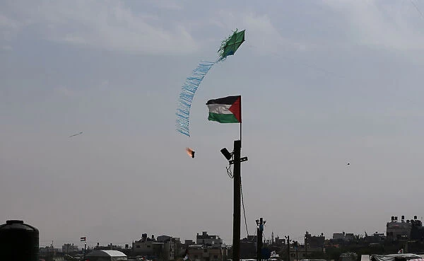 Kite is set on fire by Palestinians to be thrown at the Israeli side during clashes at a