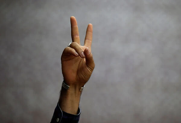 A Kurdish man flashes a sign of solidarity during a moment of silence in memory of the