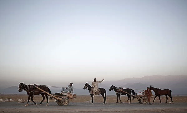 Laborers ride on their horse carts as they head to work on the outskirts of Kabul