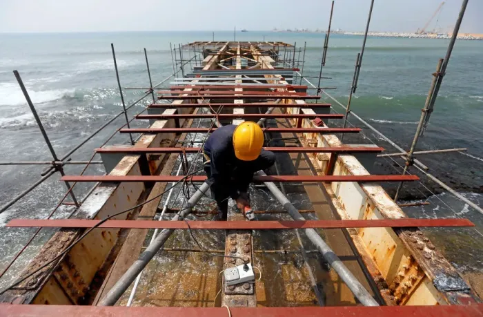Framed Print : A labourer works at a construction site of a bridge on the sea in Colombo Framed Print : A labourer works at a construction site of a bridge on the sea in Colombo