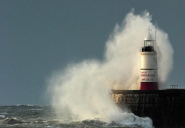 Large waves of the English Channel hit the light beacon and seawall at Newhaven in