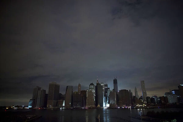 A largely unlit downtown Manhattan stands under a night sky due to a power blackout