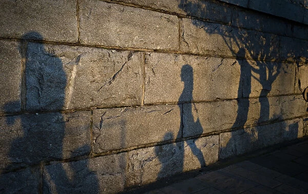 Late afternoon shadows are cast on the seawall along the inner harbour in Victoria