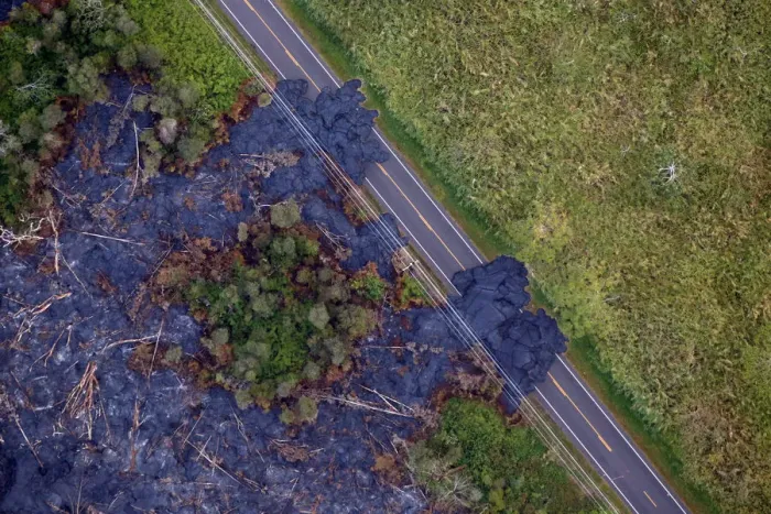 Framed Print : Lava flows across a highway on the outskirts of Pahoa