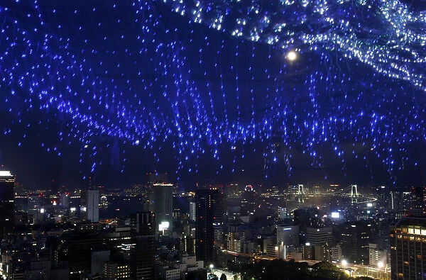 A light display of the Milky Way is reflected on a window as skyscrapers and the Tokyo
