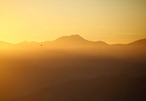 Light illuminates the mountain range and hills during the sunrise over the Nagarkot