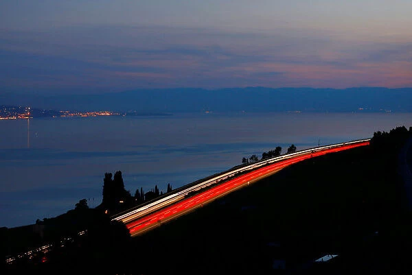 Light trails are seen on the A9 motorway overlooking Lake Leman in Chardonne near Vevey