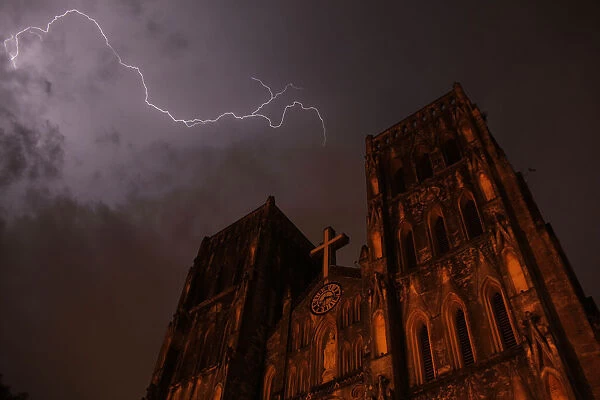 Lighting strikes over Saint Joseph cathedral during a storm in Hanoi