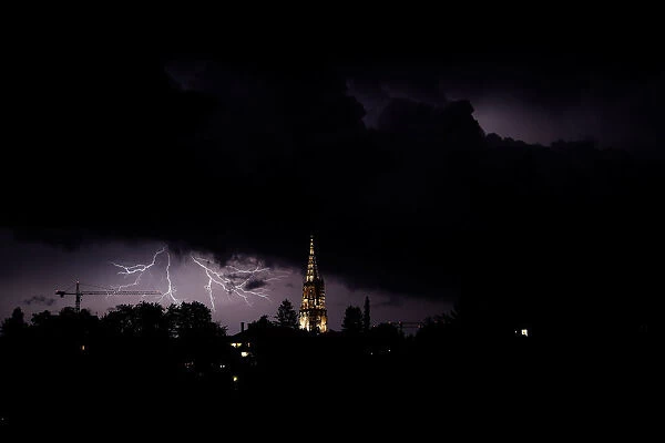 Lightning illuminates the sky above the Muenster Cathedral in Bern