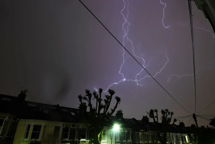 Framed Print : Lightning is seen from a bedroom window as it strikes above a street in south London