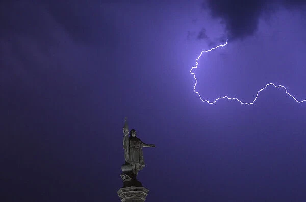 Lightning is seen in the sky above the Christopher Columbus monument at Madrids Colon
