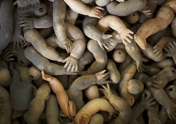 Limbs of dolls are shown as spare parts in a pile ready to be used in customers doll