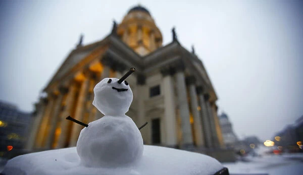 A little snowman stands at the Gendarmenmarkt square after snow falls in Berlin