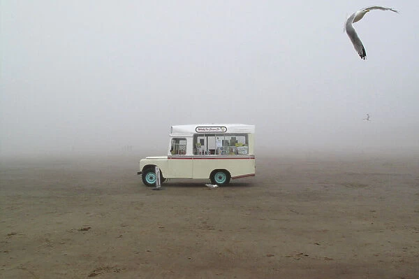 LM1E87714CK01. An ice cream van stands on a foggy beach in Whitby