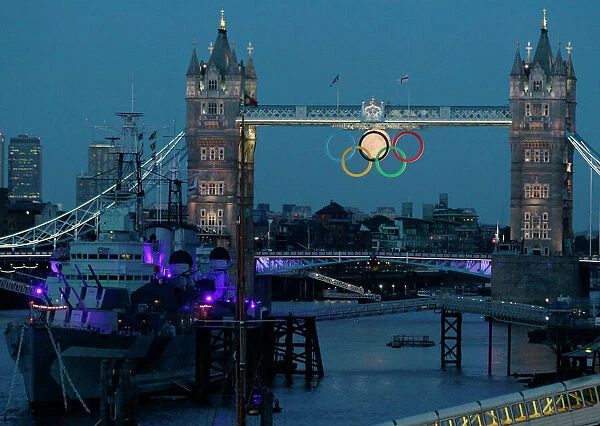 LM1E8831MP801. The full moon rises through the Olympic Rings hanging beneath Tower Bridge
