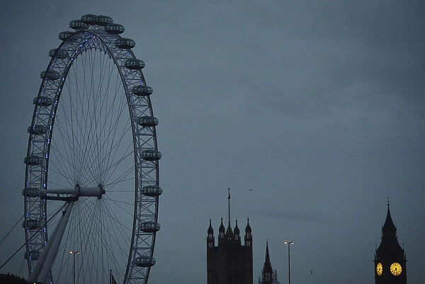 The London Eye is seen near the Houses of Parliament at dawn in central London