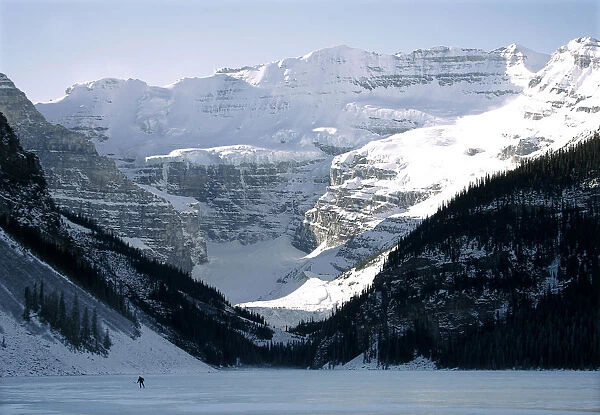 A lone hockey player skates on frozen Lake Louise in Canadas Banff National Park