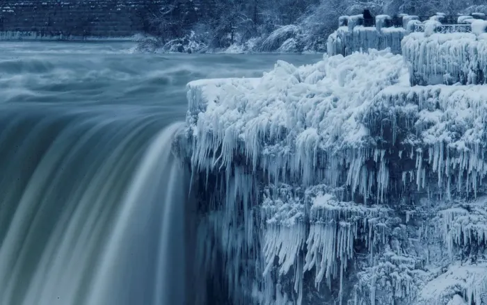 Framed Print : A lone visitor takes a picture near the brink of the ice covered Horseshoe Falls in Framed Print : A lone visitor takes a picture near the brink of the ice covered Horseshoe Falls in