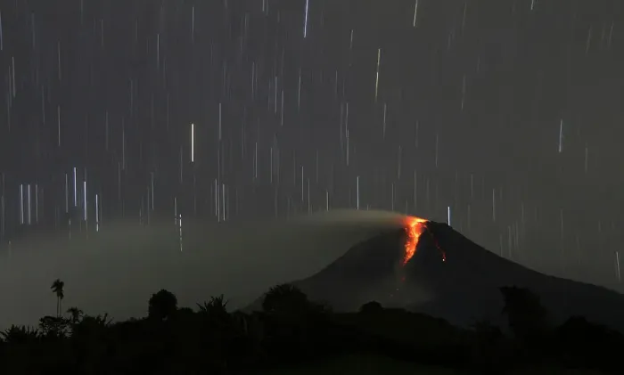 Framed Print : A long exposure photo shows star trails as Mount Sinabung volcano spews hot lava as seen Framed Print : A long exposure photo shows star trails as Mount Sinabung volcano spews hot lava as seen