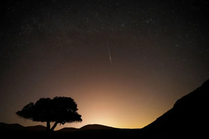 Framed Print : A long exposure shows a meteor streaking across the sky in the early morning during