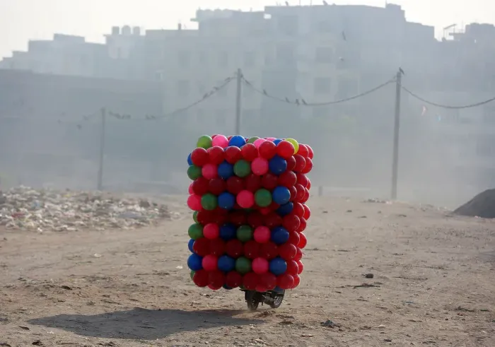Framed Print : A man carries childrens coloured plastic balls on his motorcycle in Delhi