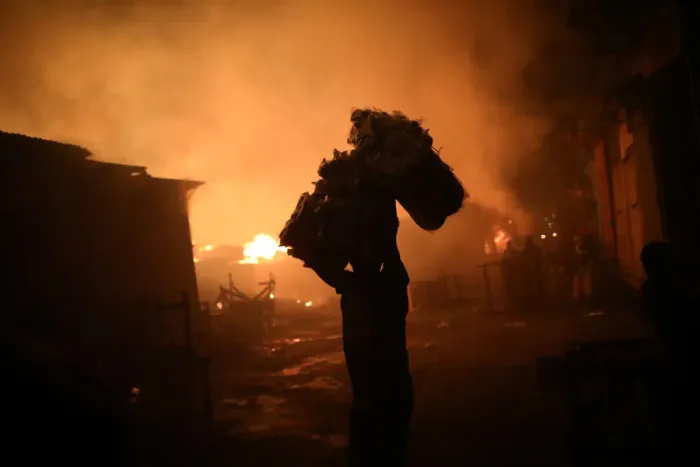 Framed Print : A man carries goods out of a fire at a market in Port-au-Prince Framed Print : A man carries goods out of a fire at a market in Port-au-Prince