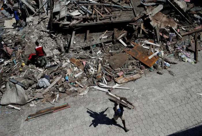 Framed Print : A man carries wooden planks salvaged from the rubble of a destroyed houses after Framed Print : A man carries wooden planks salvaged from the rubble of a destroyed houses after