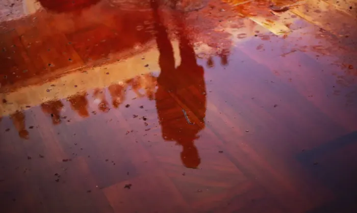 Framed Print : Man casts a reflection on the floor covered with red coloured water during Huranga