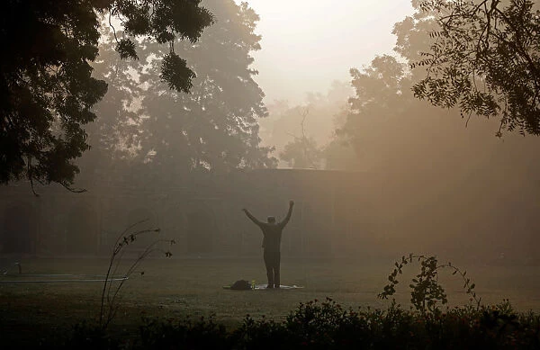A man exercises at a public park on a foggy winter morning in New Delhi