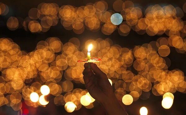 A man hold a candle during a Christmas mass at the Gelora Bung Karno stadium in Jakarta