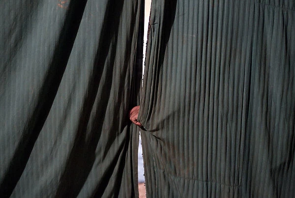 A man holds the curtains before the start of an act at the Jan Baz circus
