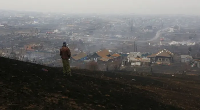 Framed Print : Man looks downhill at the settlement of Shyra, damaged by recent wildfires