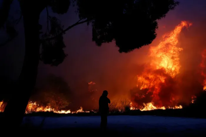 Framed Print : A man looks at the flames as a wildfire burns in the town of Rafina