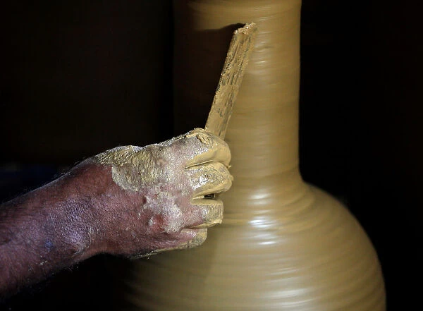 A man makes a clay pot at his workshop in Biyagama
