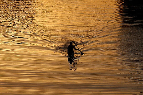 A man paddles in the Yarkon river in Tel Aviv