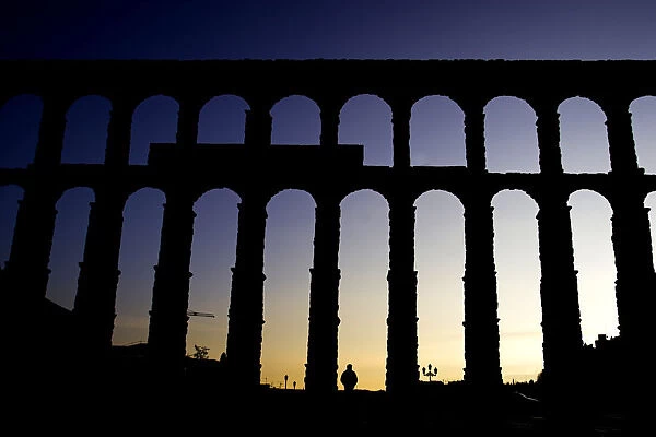 Man passes in front of Segovias 2, 000-year-old Roman aqueduct in central Spain