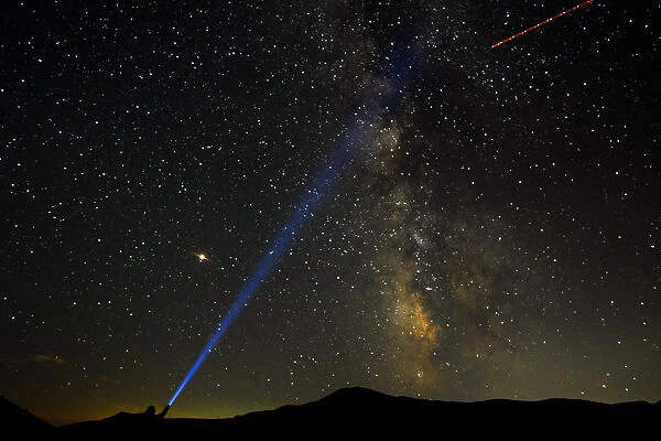 A man points his light at the Milky Way during the peak of the Perseid meteor shower in