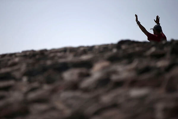 A man raises his arms towards the sun to welcome the spring equinox while he is standing