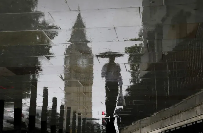 Framed Print : A man is reflected next to Big Ben on a wet pavement during a rainy day in central London Framed Print : A man is reflected next to Big Ben on a wet pavement during a rainy day in central London
