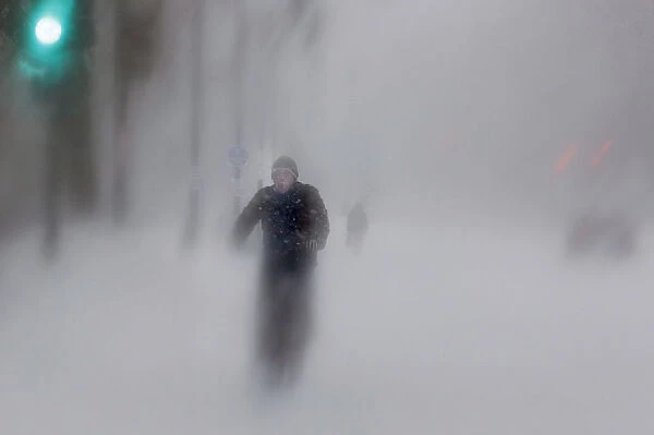 A man rides his bike up Beacon Street during a blizzard in Boston