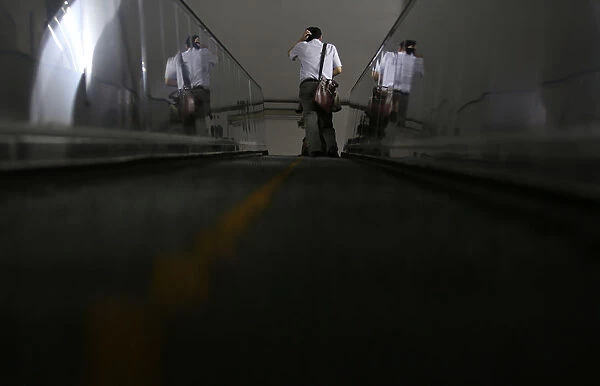 A man rides an escalator at a subway station in Beijing