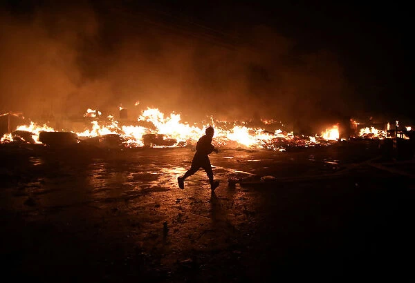 A man runs next to fire at a market in Port-au-Prince