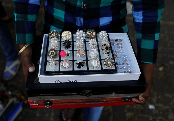 Man sells artificial jewellery at a market in Mumbai