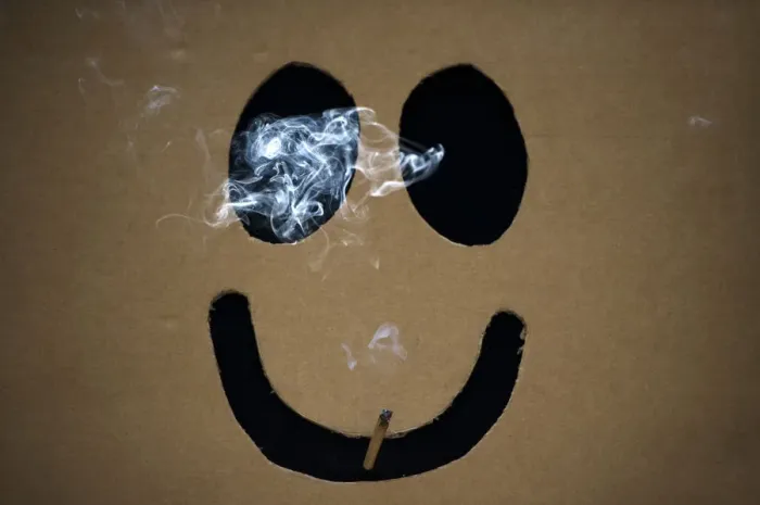 Framed Print : A man smokes a marijuana joint inside a box with a happy face cut out before The Global Framed Print : A man smokes a marijuana joint inside a box with a happy face cut out before The Global