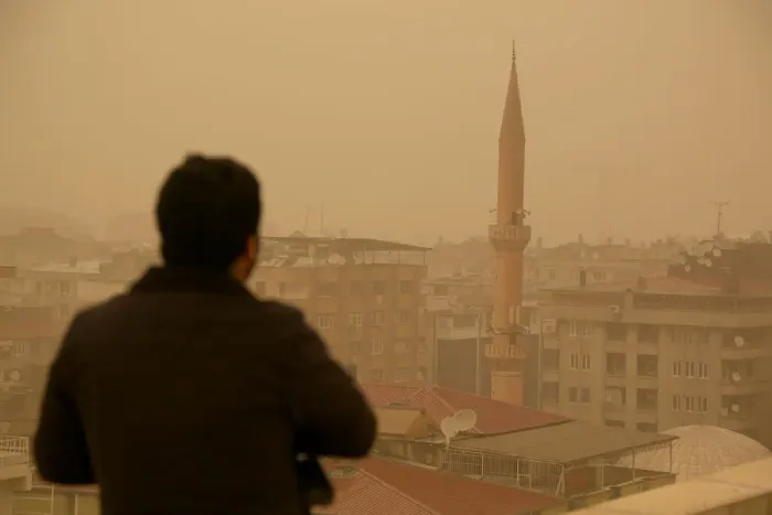 Framed Print : A man stands on top of a building during a dust storm in Diyarbakir