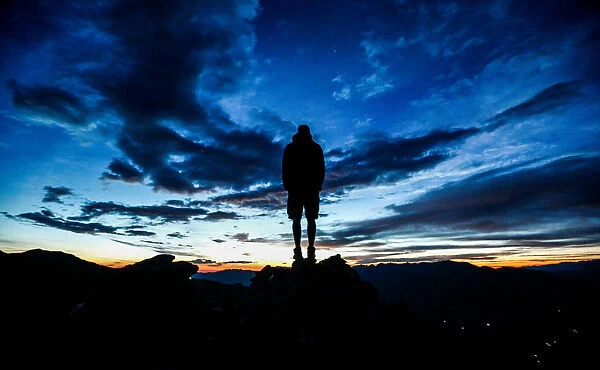 A man stands during sunrise on Kreuzjoch mountain in the Zillertal Alps in Schwendau